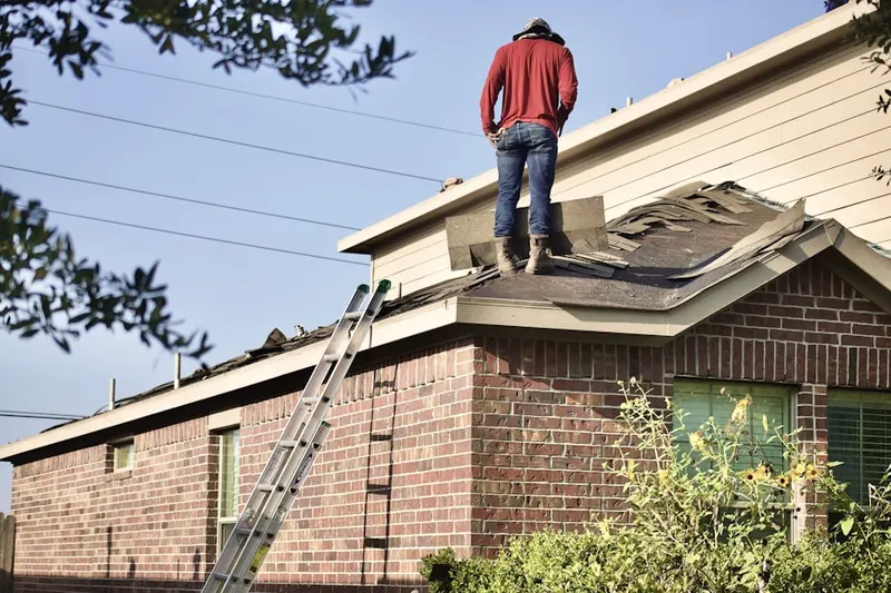 Professional roofer working on a residential roof in Breezewood Estates